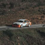 Klasyczny rajdowy polski Fiat pędzi przez malowniczą wiejską drogę