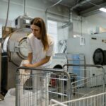 Pracownicy obsługują pranie w pralni z przemysłowymi pralkami i suszarkami