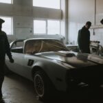 Mechanicy podczas renowacji zabytkowego auta w ciemnym garażu