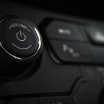 Pokrętło głośności i przyciski nowoczesnego audio na desce rozdzielczej